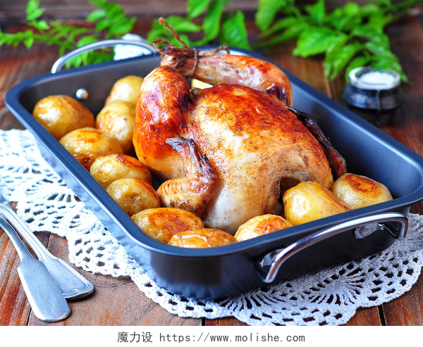 在一张木桌上的烤鸡在一张木桌上的烤土豆烤的鸡